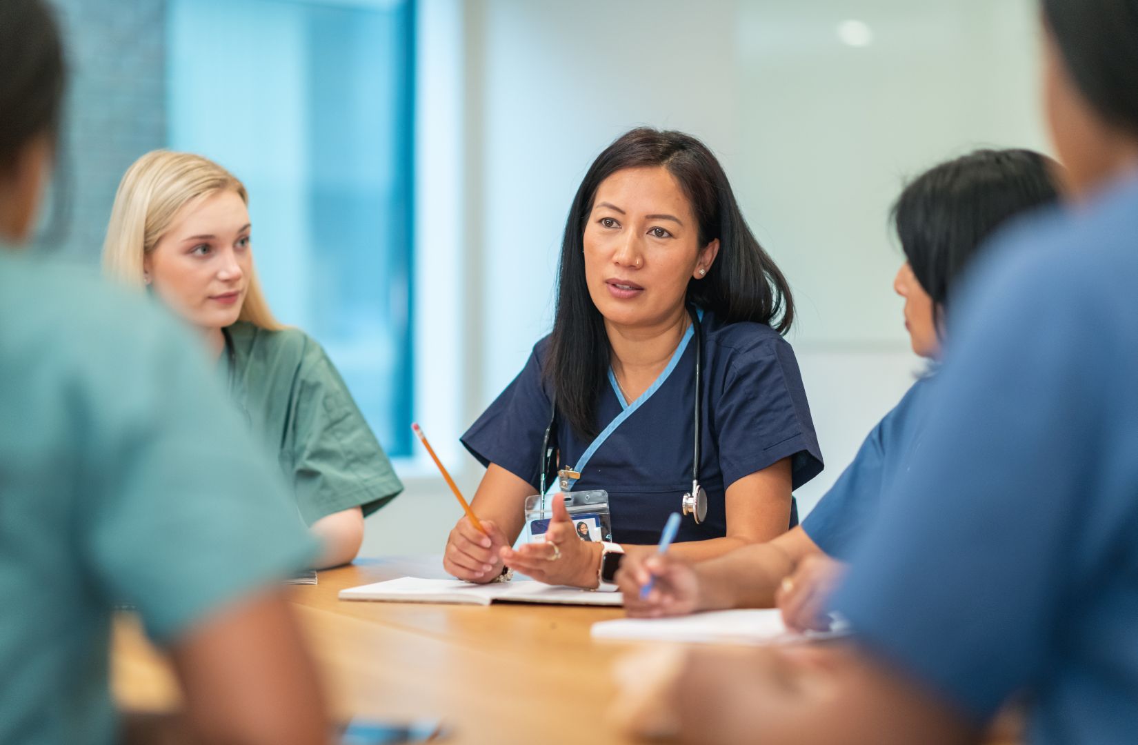 A group of health professionals sit at a table having a discussion